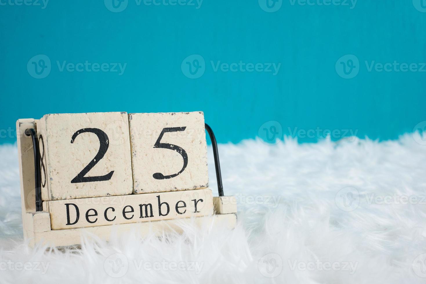 Christmas day theme .wood cube block calendar present date 25 and month December.copy space for text.Celebration Christmas and x'mas concept.on green background photo