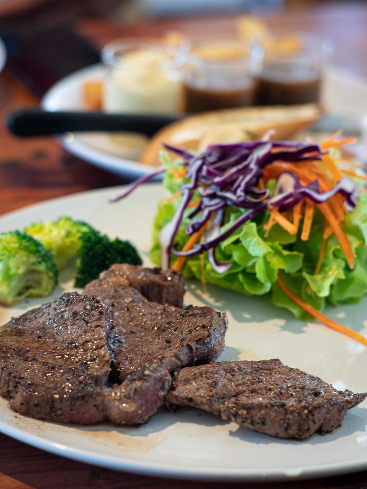 bistec hecho de carne de res y semillas de pimienta negra en un plato de cerámica blanca en el restaurante foto