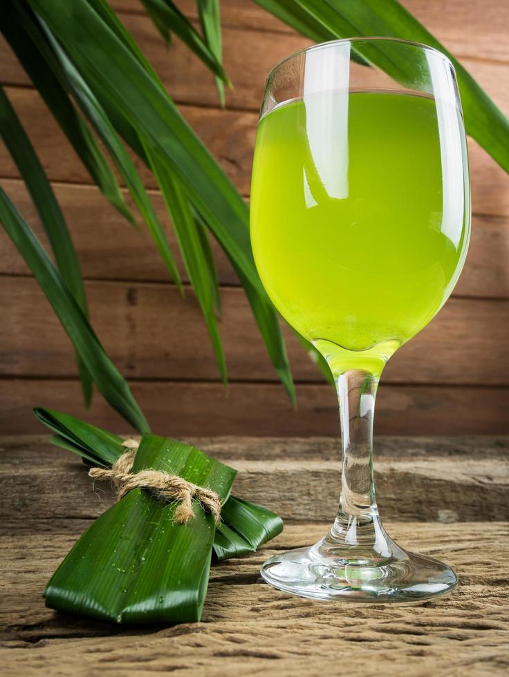 Pandan and pandan juice is made from crushed or boiled. It healthy drink in clear glass placed on wooden floor.Shot in the studio.Close up view photo