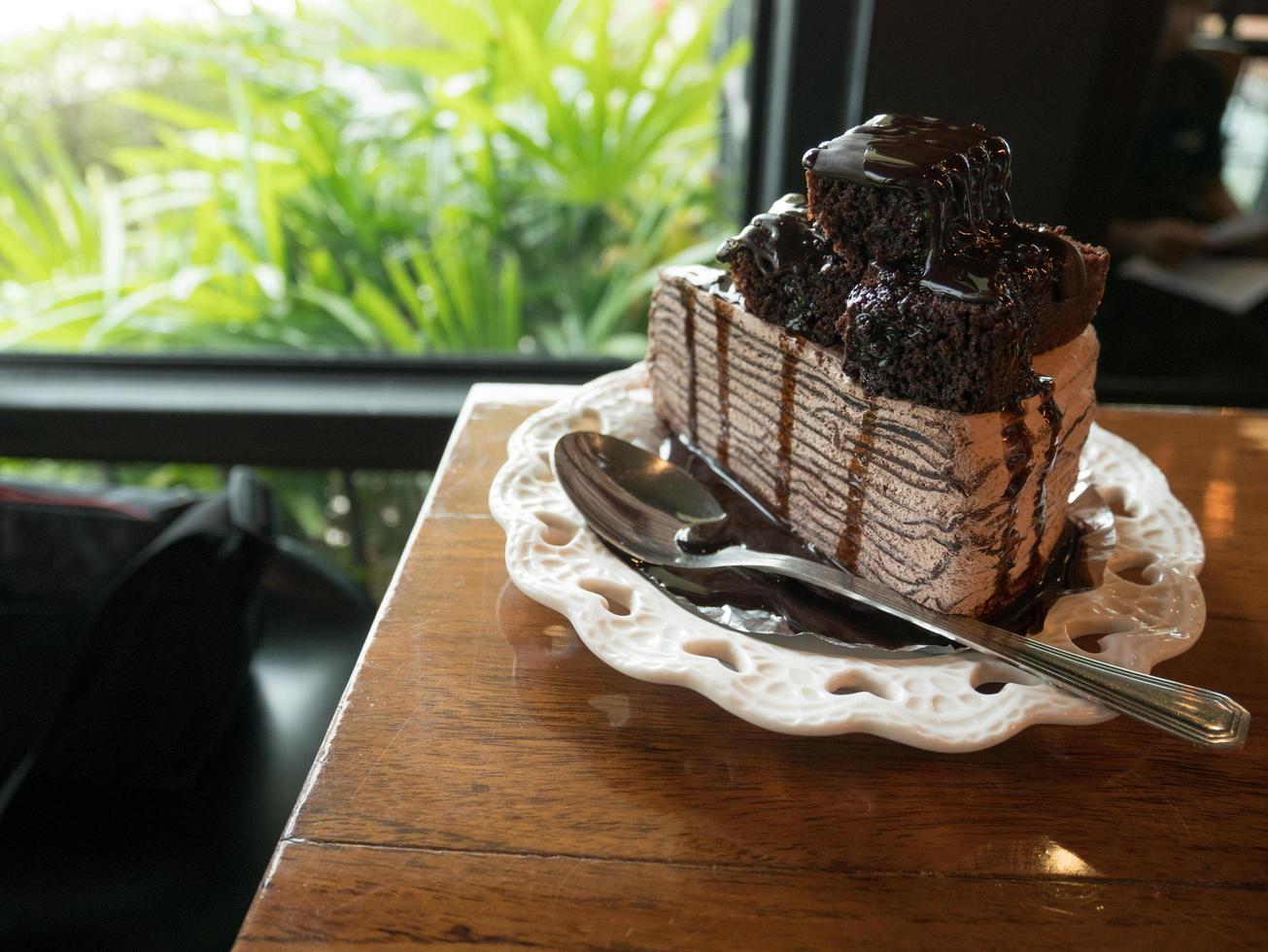 Chocolate cake with brownie and vanilla on a white plate on a wooden table at a coffee shop.Selective focus photo