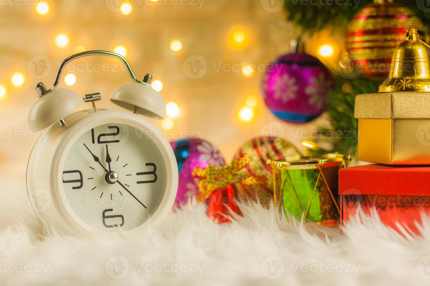 Christmas Retro alarm clock.decoratied with gift box and fir festive on blurred bokeh background.Celebration and Happy New Year Concept. photo