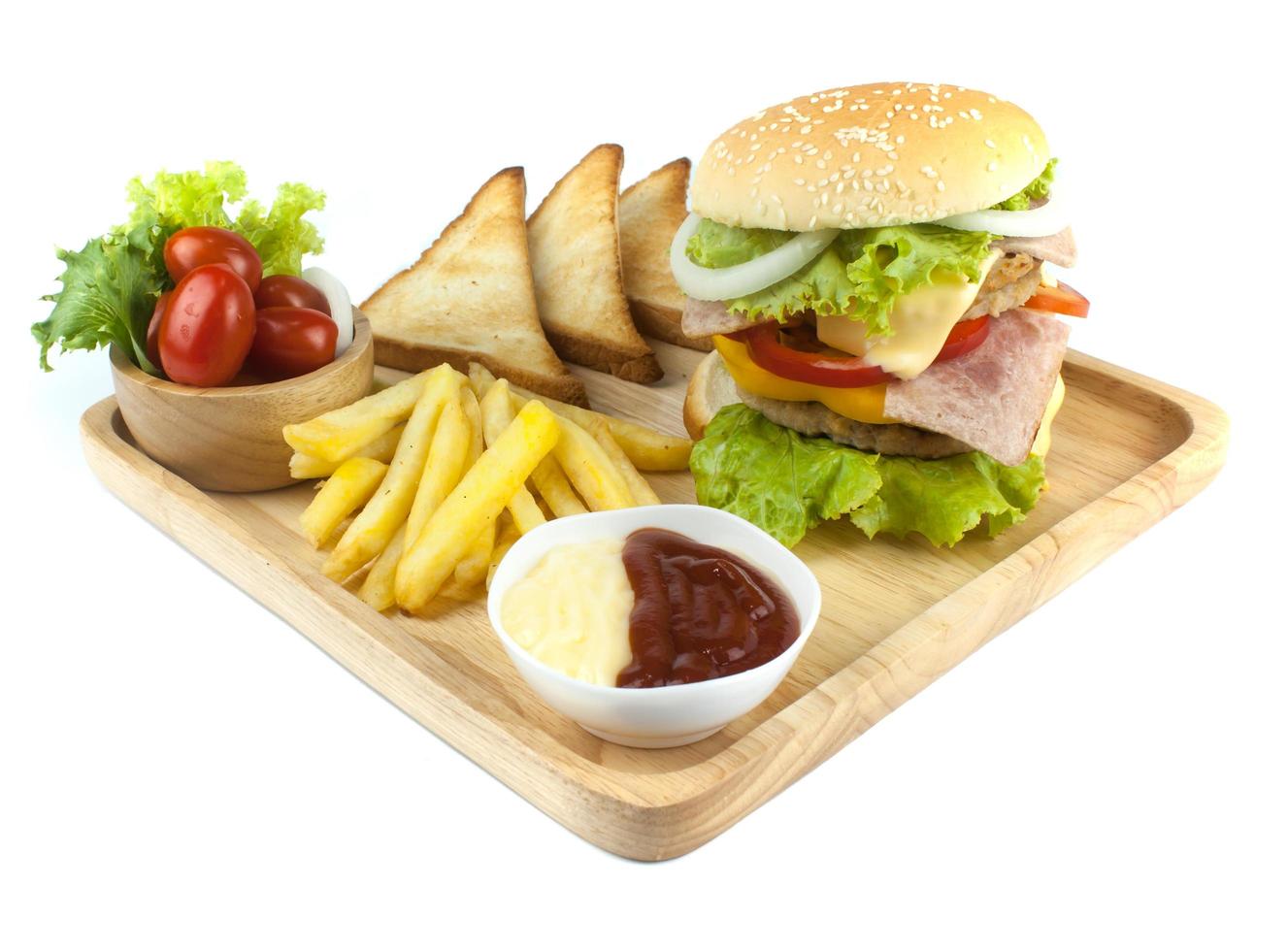 Pork hamburger Homemade with grilled bacon contains vegetables, cheese, lettuce, onion, chilli, spices in a wooden dish isolated on white backgroud photo