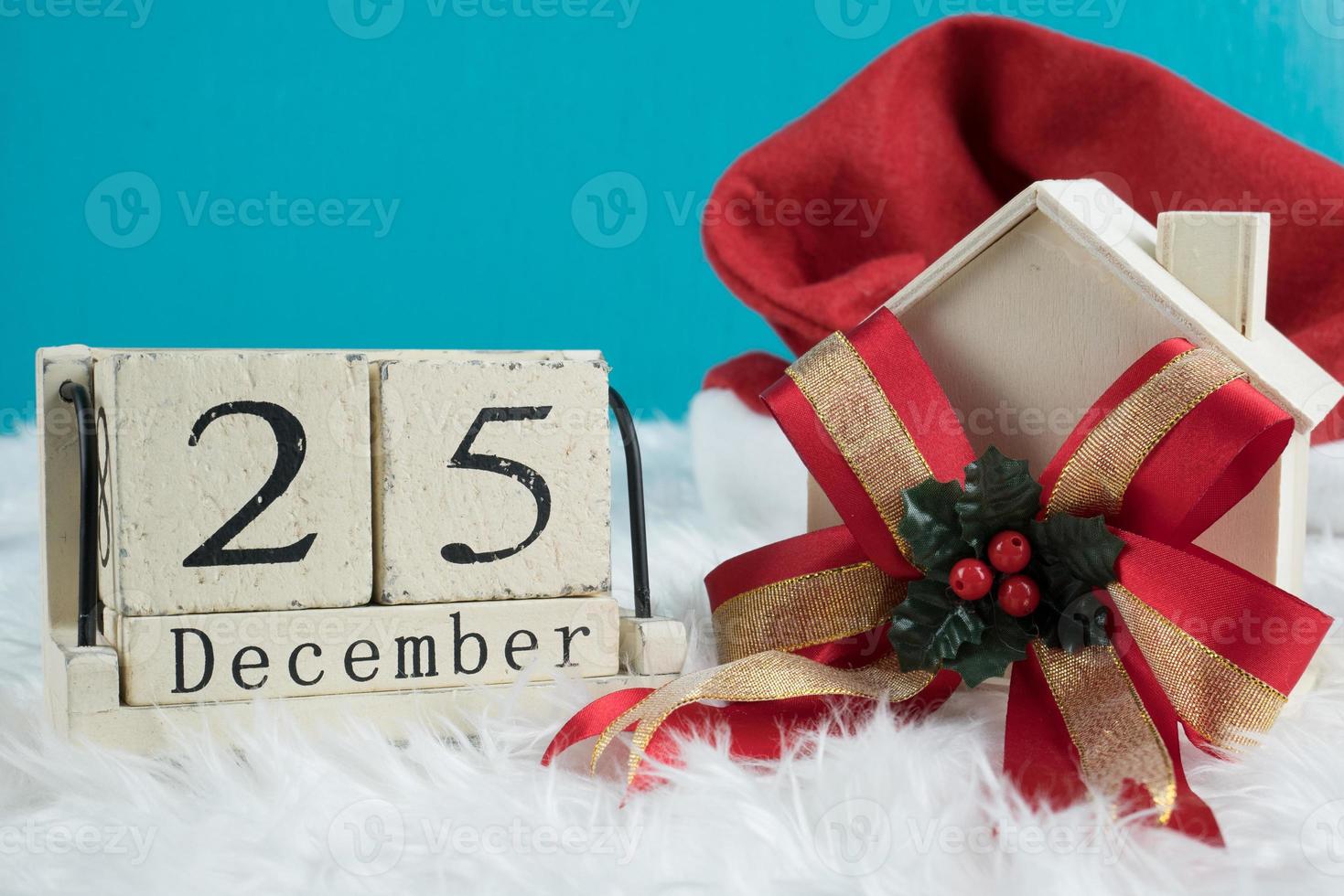 Christmas day theme decoration with hat santa,wooden toy and wood cube block calendar present date 25 and month December.copy space for text.Celebration Christmas and x'mas concept.on green background photo