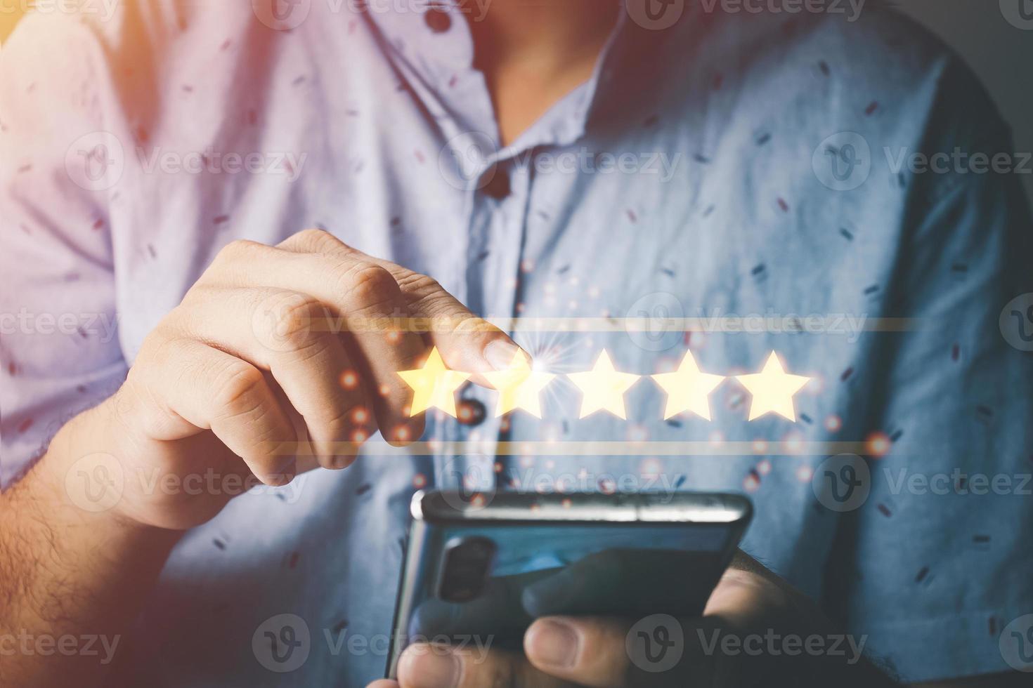 Customer Satisfaction Survey Concept, A man's hand using a smartphone gives a 5 star rating to show the highest level of satisfaction with excellent service.. photo