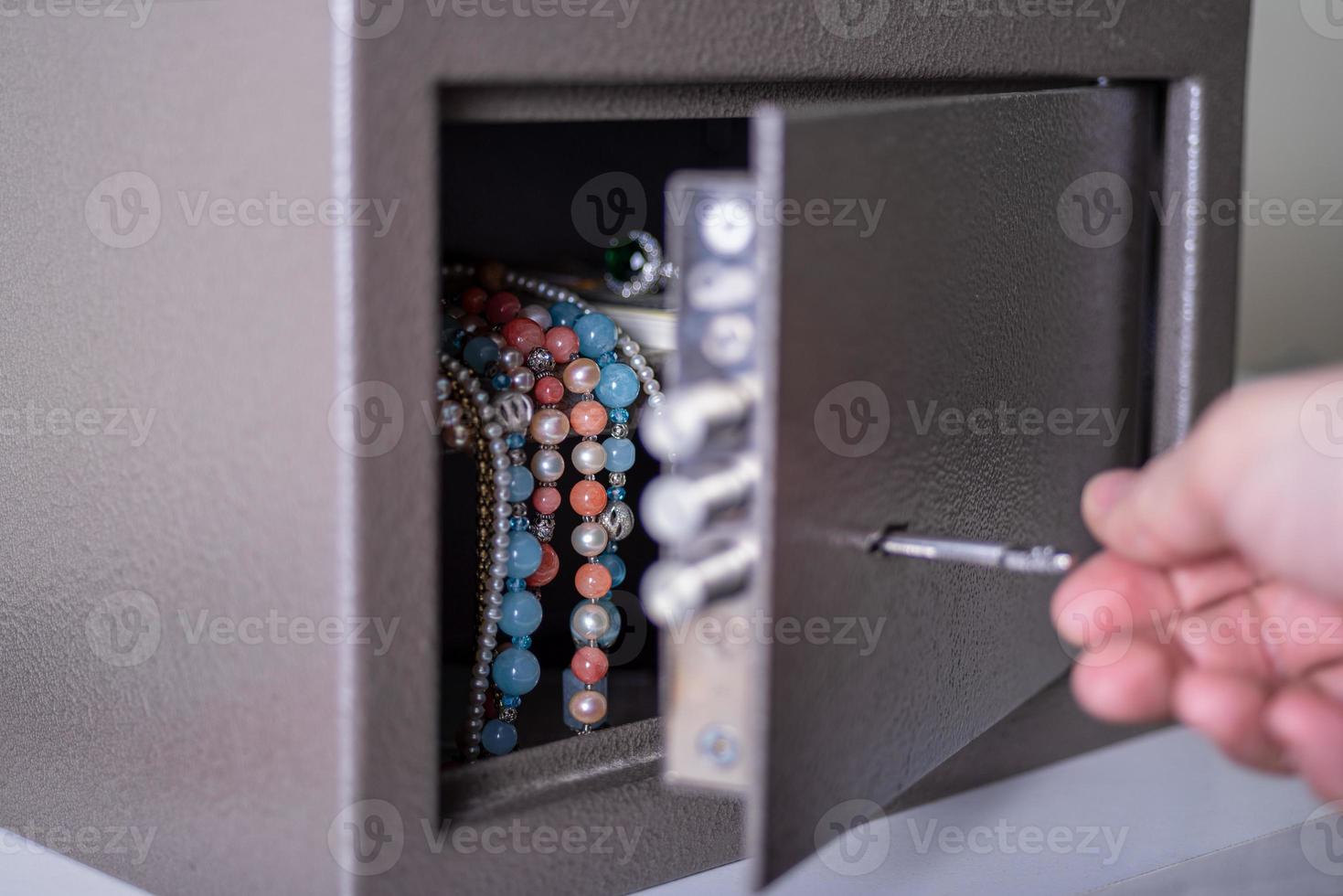 Money and jewelry in an open safe on the table. photo