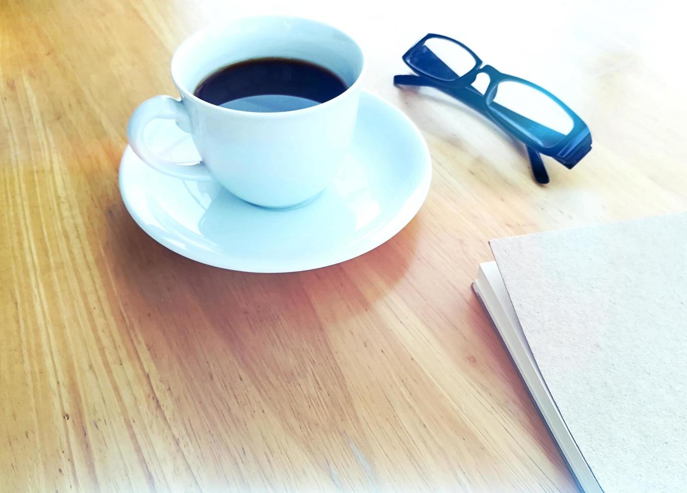 Hot coffee, glasses and notebooks on the table. photo