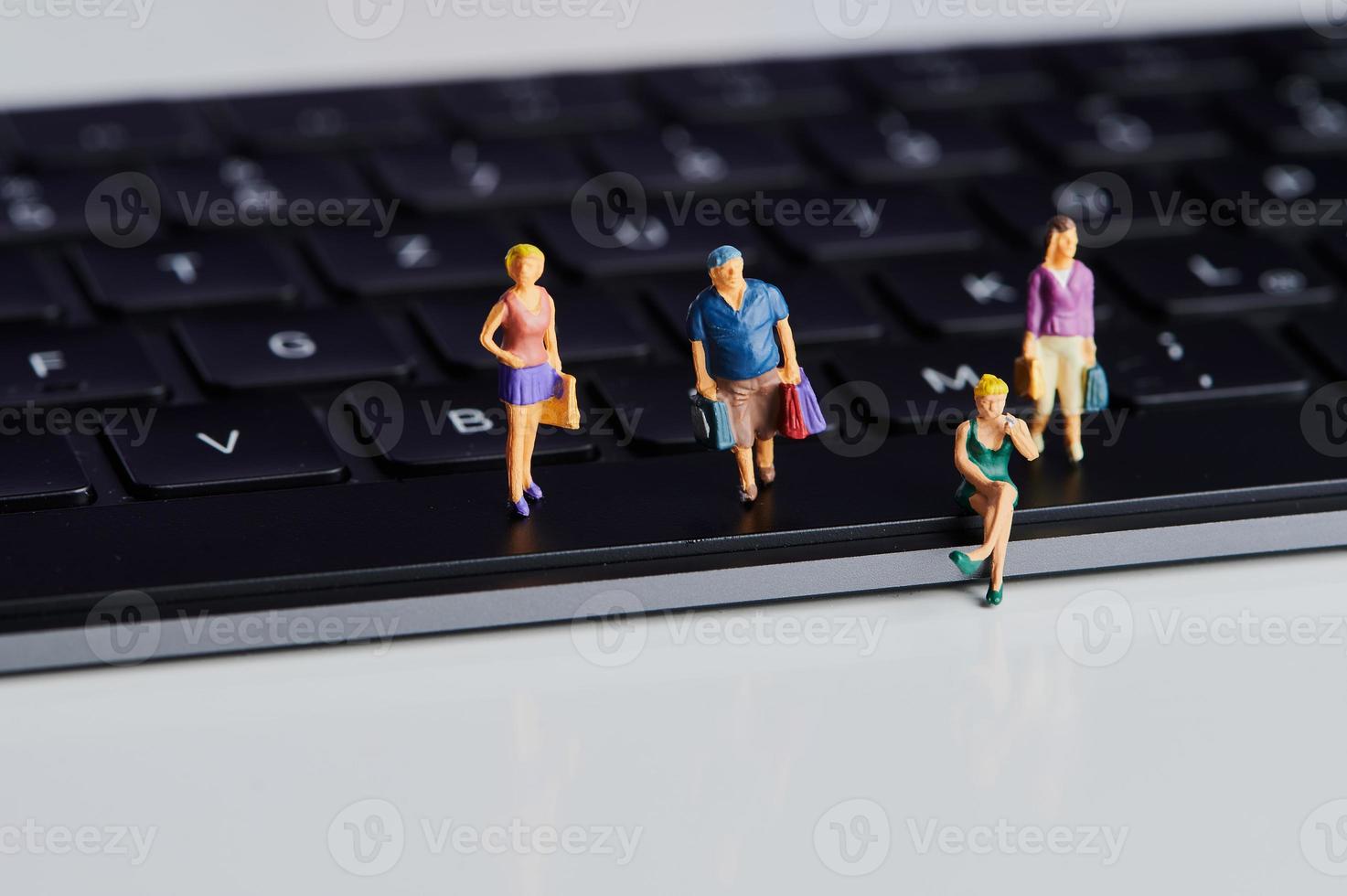 miniature people with shopping bags on a computer keyboard photo