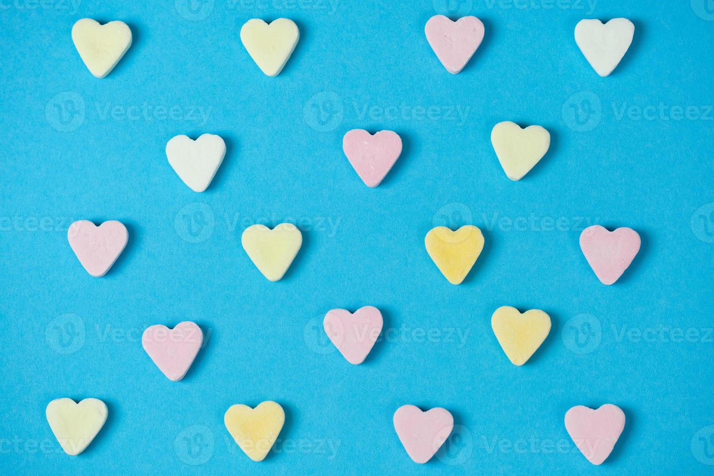 blue background with sugar hearts in rows photo