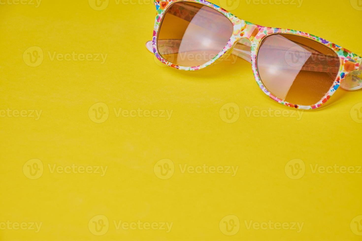 summer background with sun glasses on yellow background photo