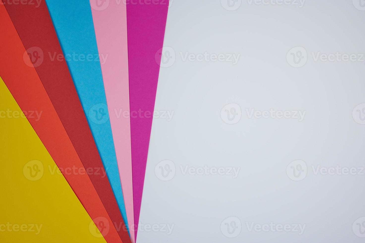 six colored papers laid in a fan pattern on a white paper as background photo