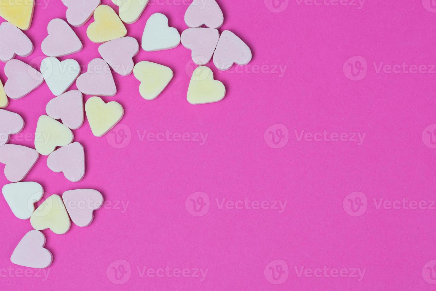 candy hearts lying in the corner on a pink background photo