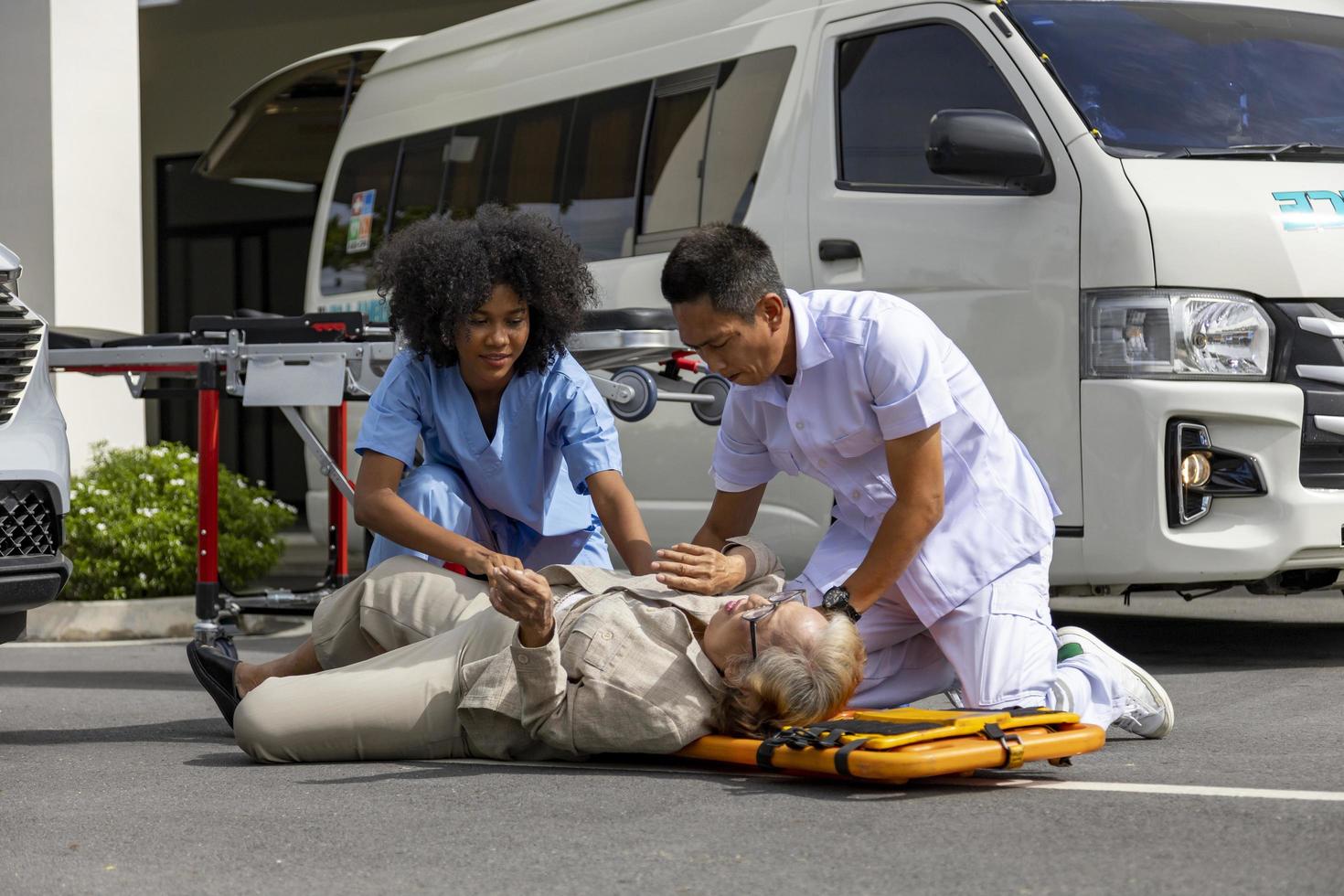 Team of paramedic is helping the senior patient from car crash by using spinal board to transfer into the ambulance for first aid and street accident concept photo