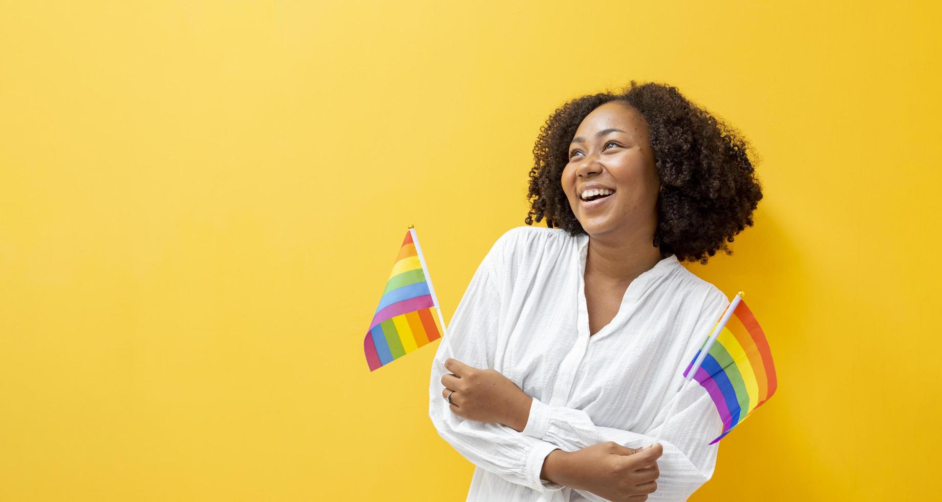 Portrait of African woman waving LGBTQ rainbow flag for coming out of the closet in pride month to promote marriage equality and differences of homosexual and discrimination concept photo