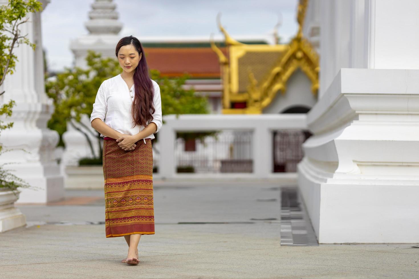 mujer asiática budista está haciendo meditación caminando alrededor del templo por la paz y el concepto de práctica de religión tranquila foto