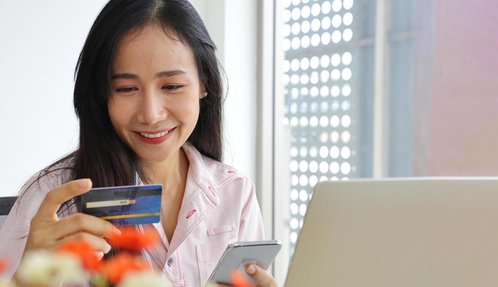 Asian woman using credit card for online banking service to purchase product from Internet with copy space photo