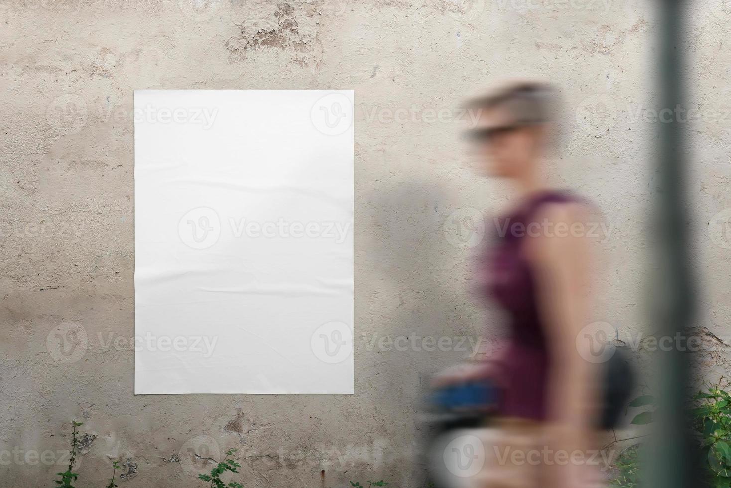 maqueta de póster en blanco en la pared para presentación de diseño. una mujer joven pasa caminando foto