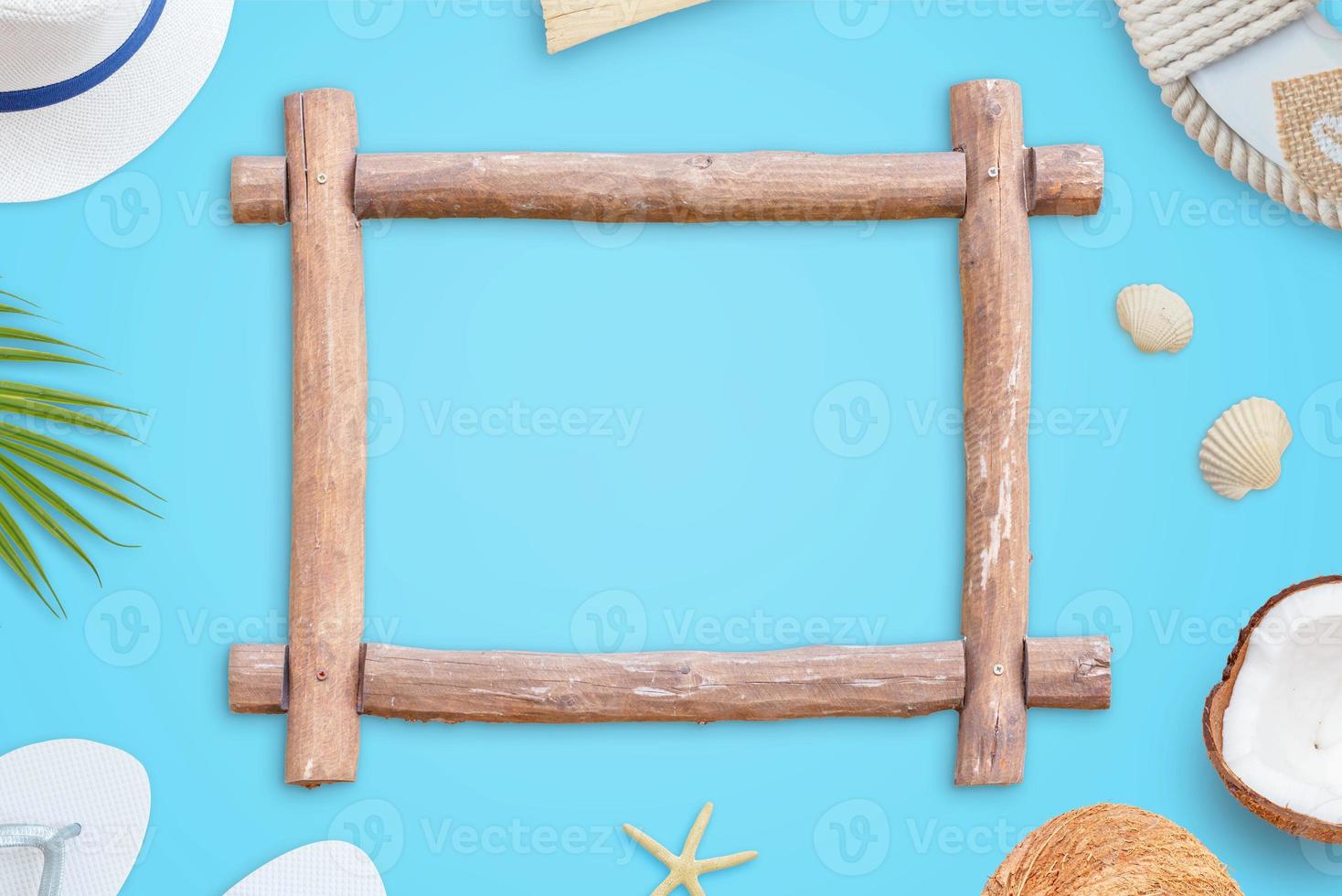 Wooden frame on blue surface. Summer travel concept. Top view, flat lay composition. Free space in the frame for text promotion photo