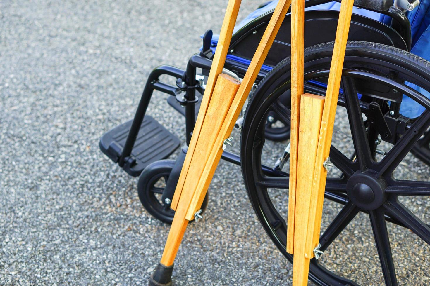 The crutches lean against the wheelchair in open spaces or outdoor