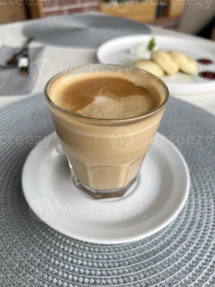 flat white - coffee drink. breakfast in a cafe. coffee in a glass saucer - large view photo