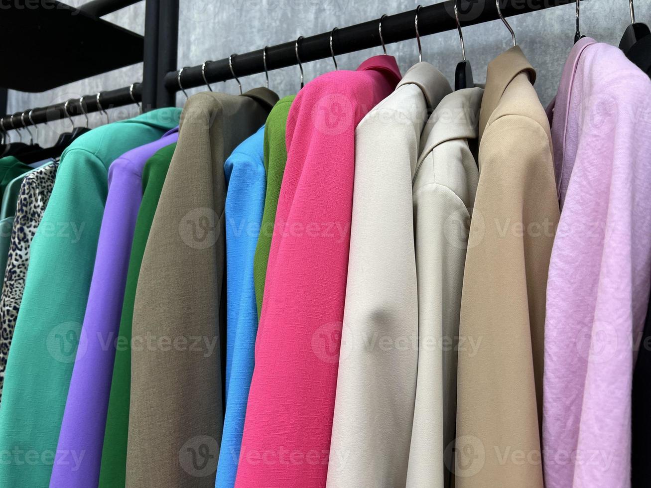cosas multicolores en una percha en la tienda. chaquetas gama mujer. venta de ropa foto