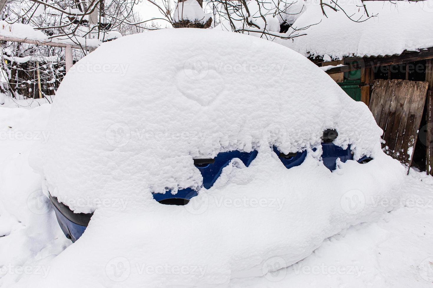 A Car in the yard with a large snowdrift photo