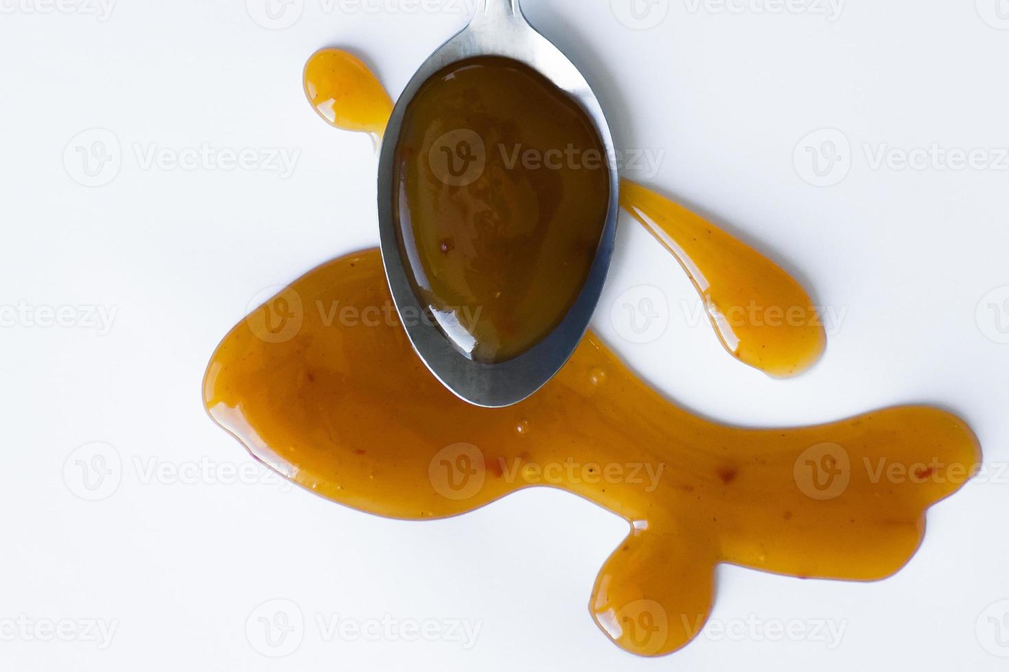 the drops of homemade sauce and a spoon on a white background photo