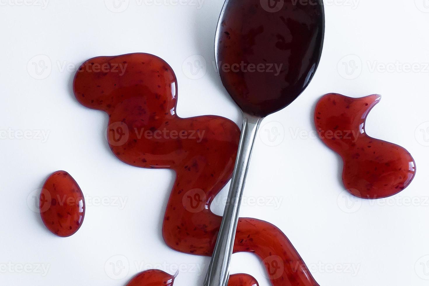the drops of homemade sauce and a spoon on a white background photo