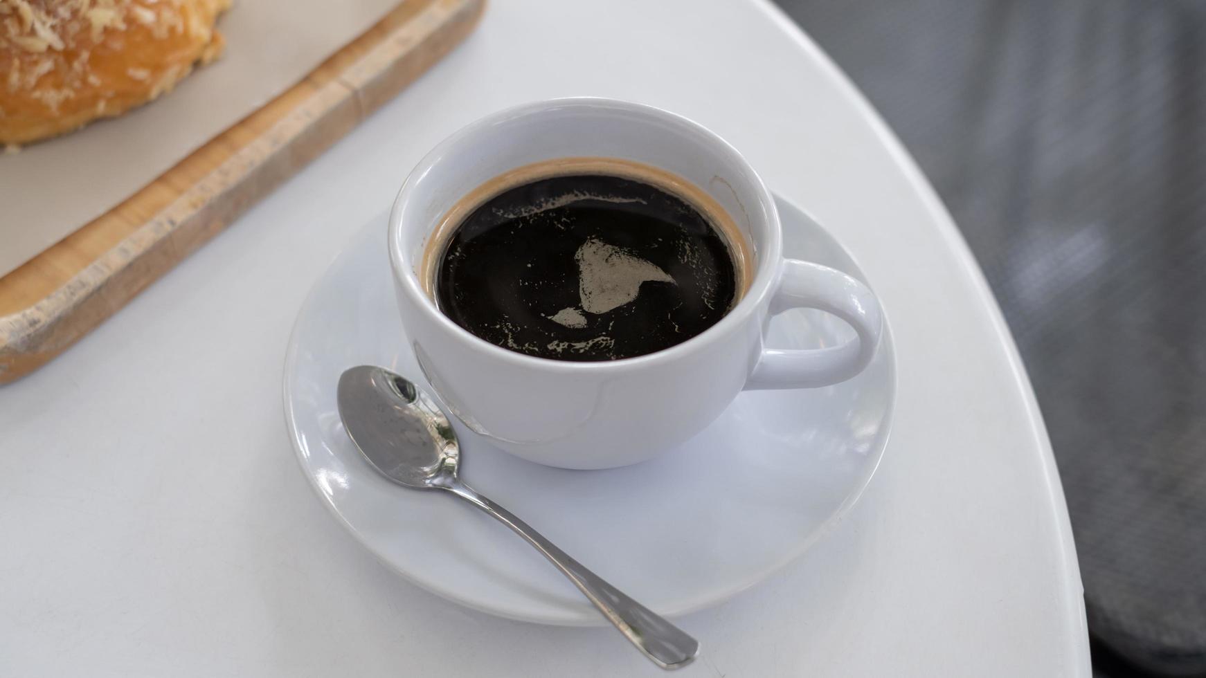 a cup of coffee on white table with work break time, food concept. Close up of a glass of hot espresso mix Soft drink with copy space photo