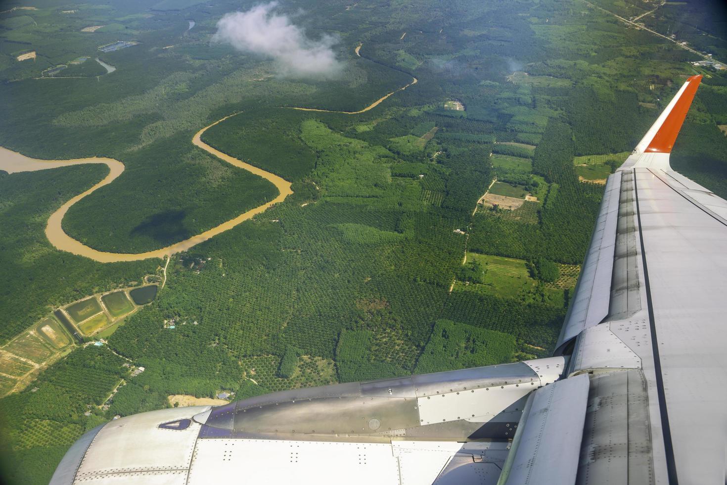 wings of airplanes during the flight look from the passenger window. There are white clouds in the blue sky. photo