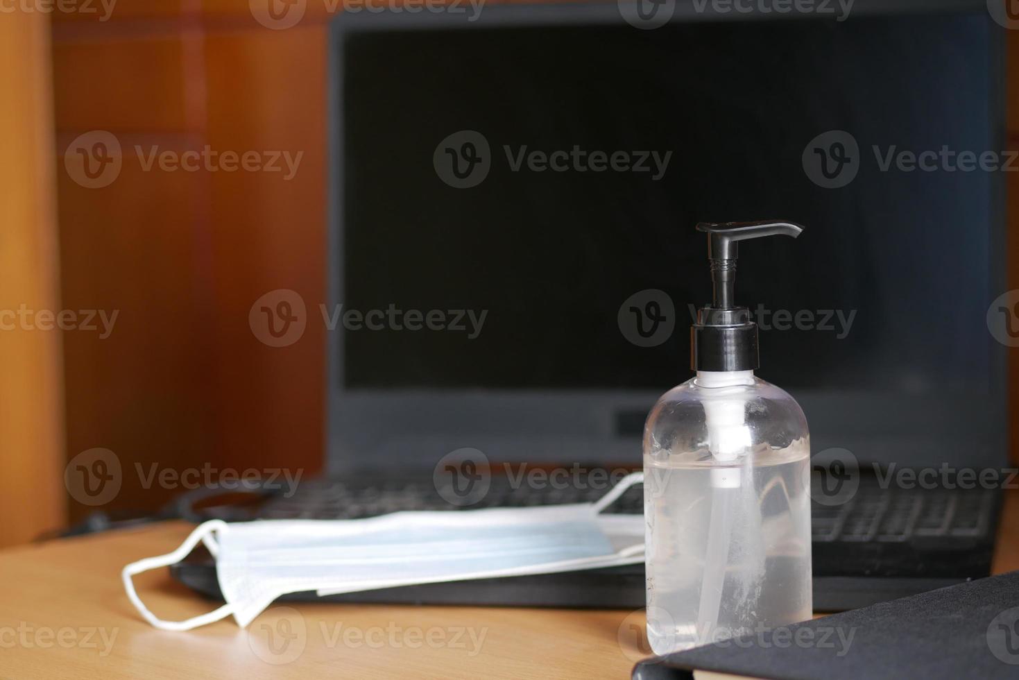 Close up of blue surgical masks and hand sanitizer on table photo