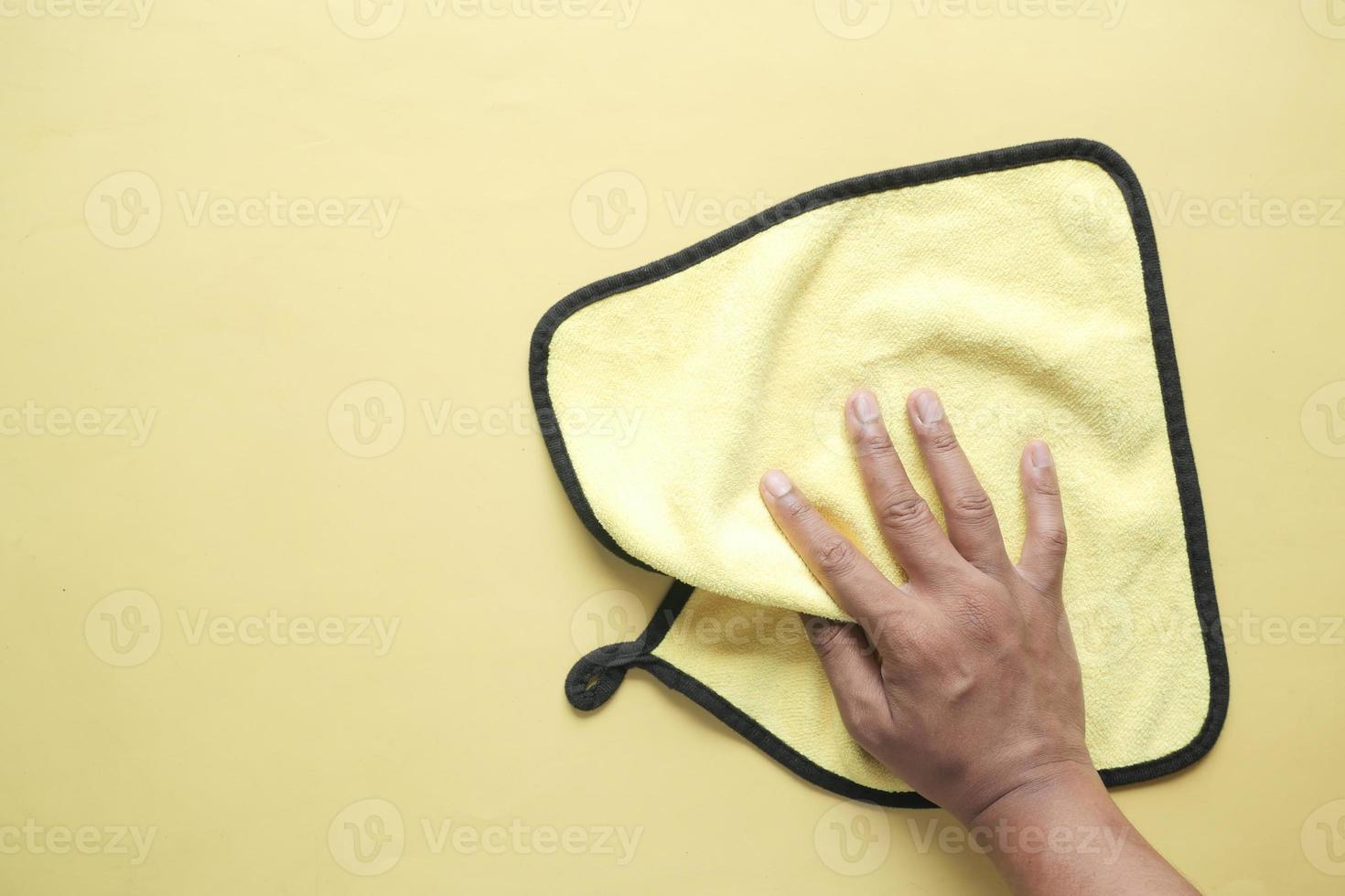 top view of person hand cleaning table with yellow cloth photo