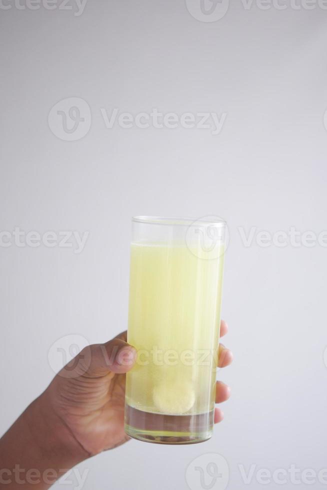 holding a glass of water with Effervescent soluble tablet pills photo