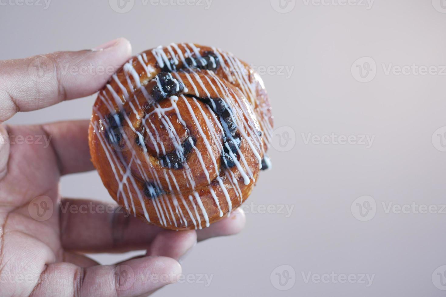 close up holding a cinnamon danish roll photo