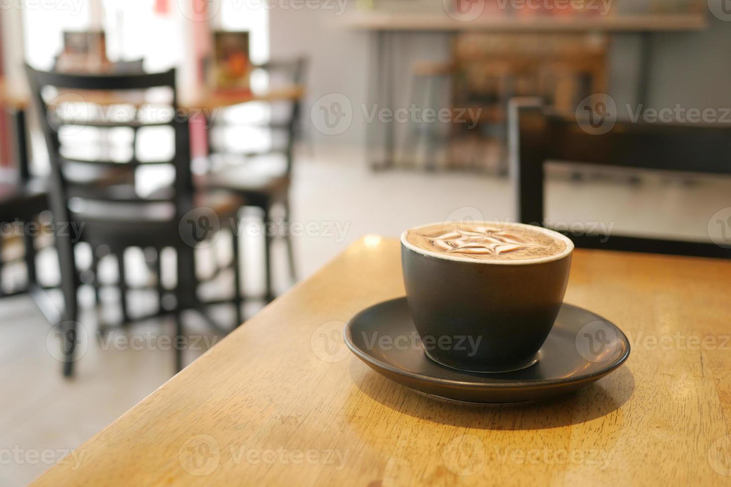 a cup of late coffee with flower shape design on top at cafe photo