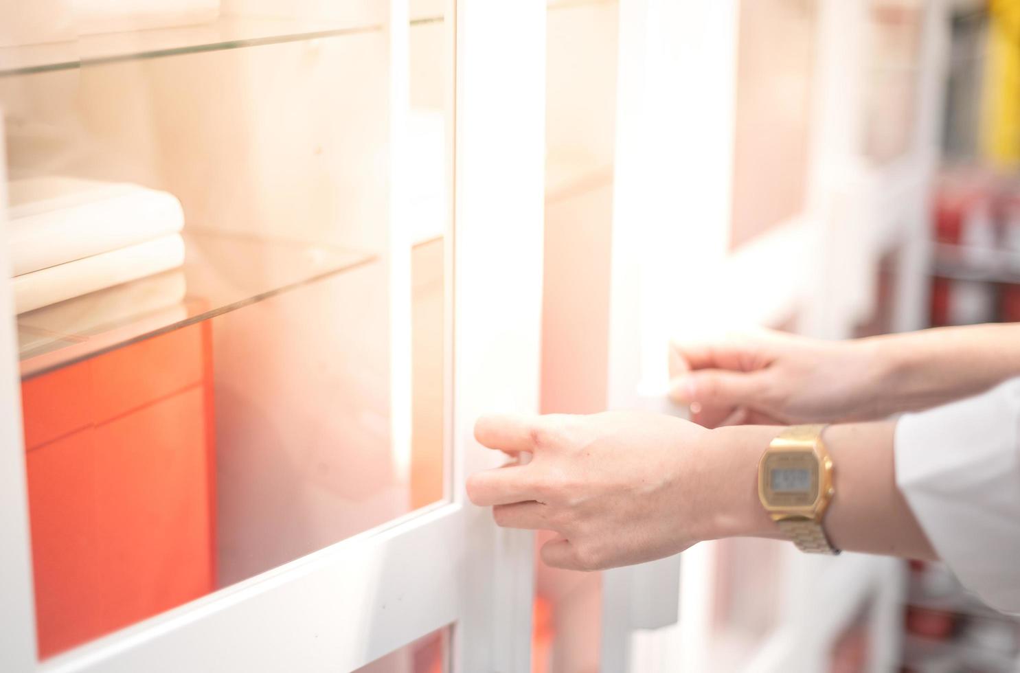 Female hand opening white document cupboard for choosing the document at the working office. photo