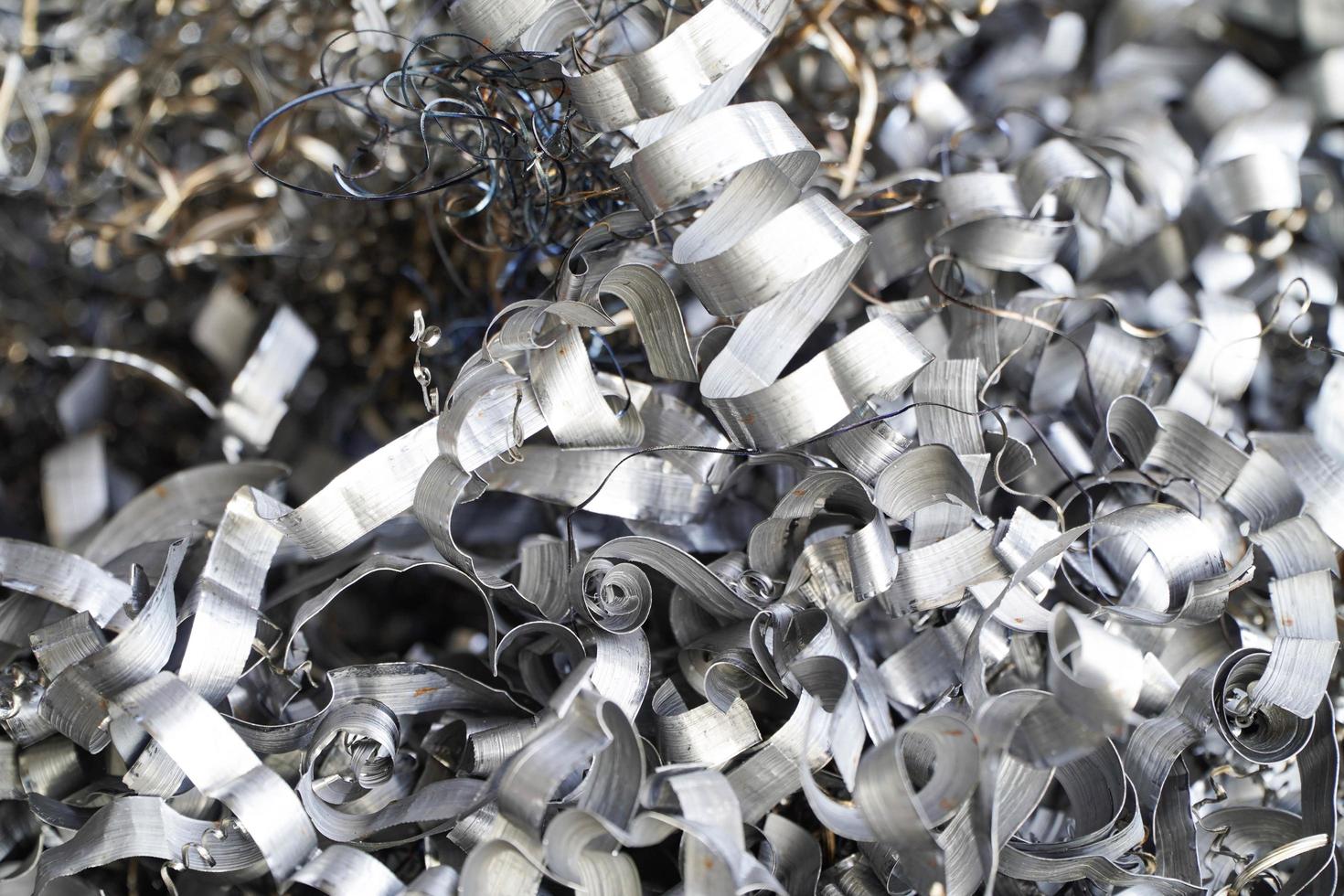 Steel scrap materials recycling. Aluminum chip waste after machining metal parts on a cnc lathe. Closeup twisted spiral steel shavings. Small roughness sharpness, photo