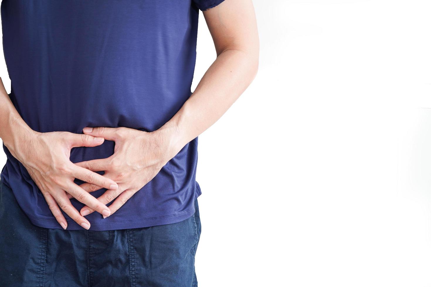 hombre con dolor abdominal, dolor de estómago en fondo blanco, área dolorosa resaltada en rojo foto