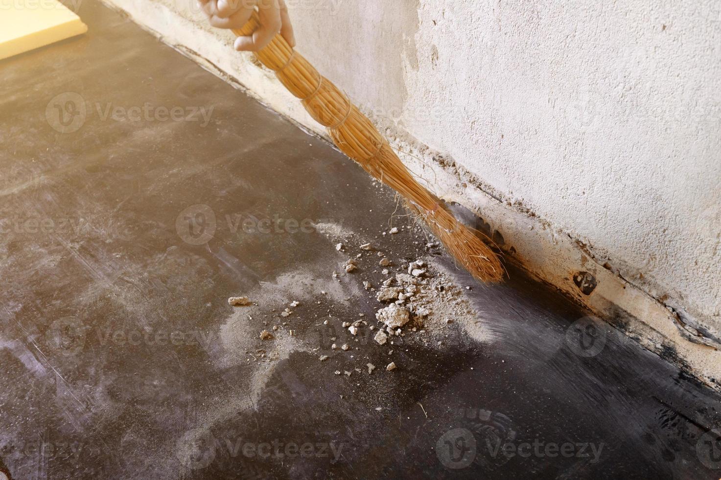 Worker sweeps construction debris with a broom. photo