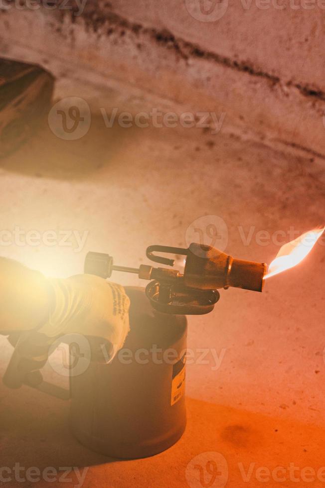 Gasoline blowtorch with a burning fire, the use of a blowtorch in construction. photo