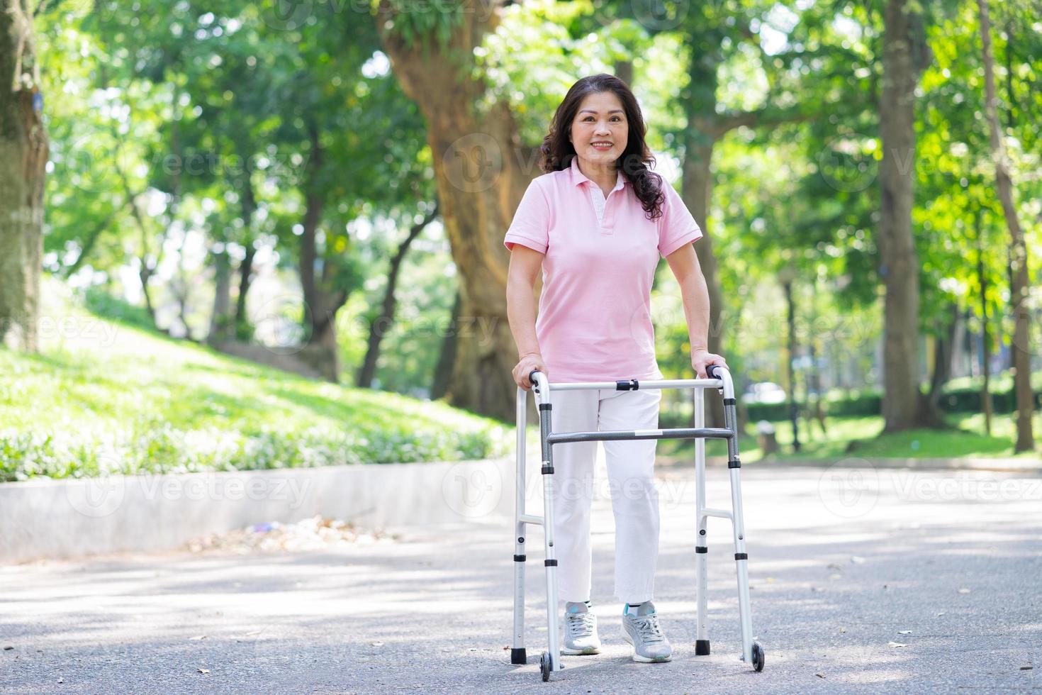 Image of middle age Asian woman practicing walking in the park photo