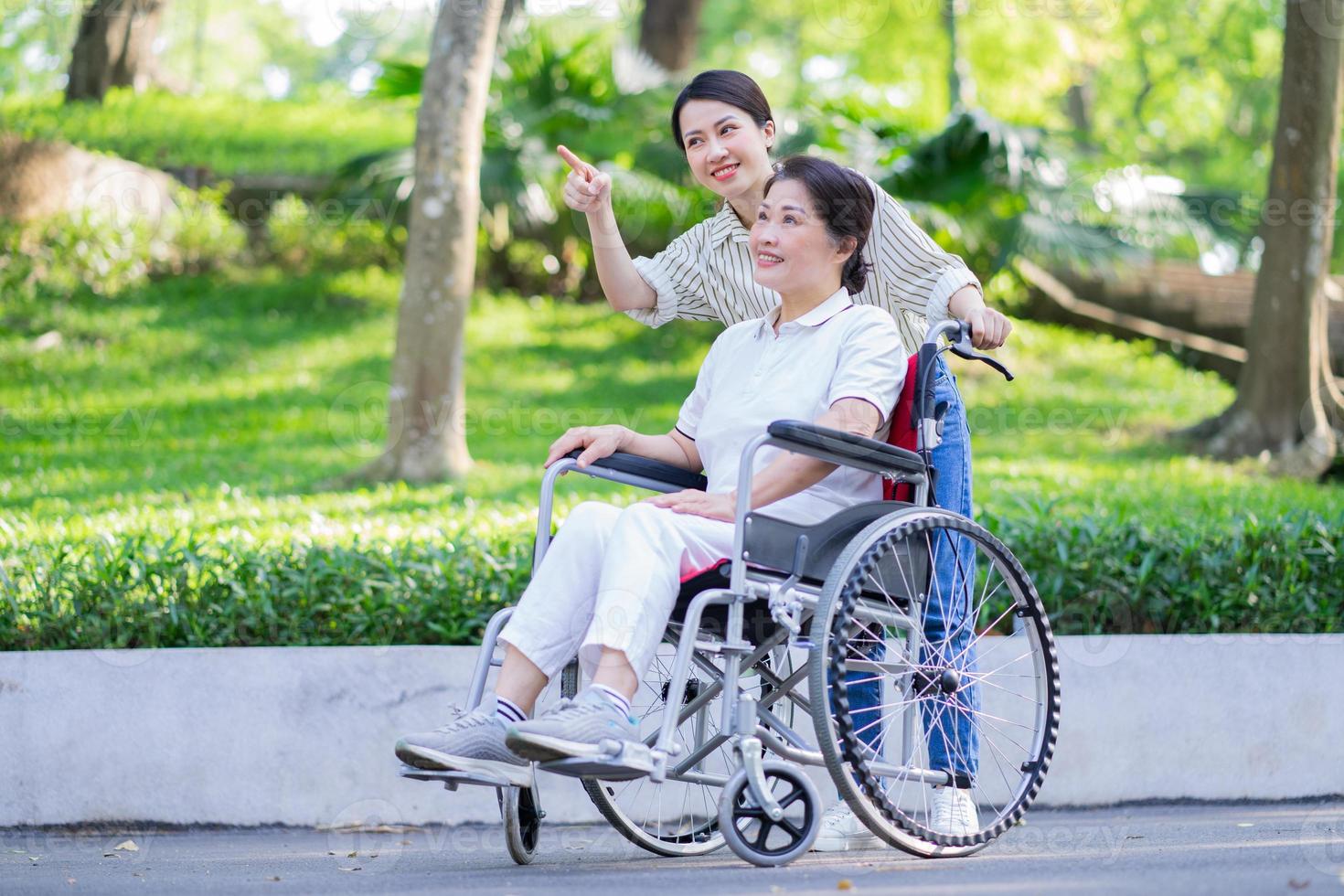 Young Asian daughter taking care of her disabled mother photo