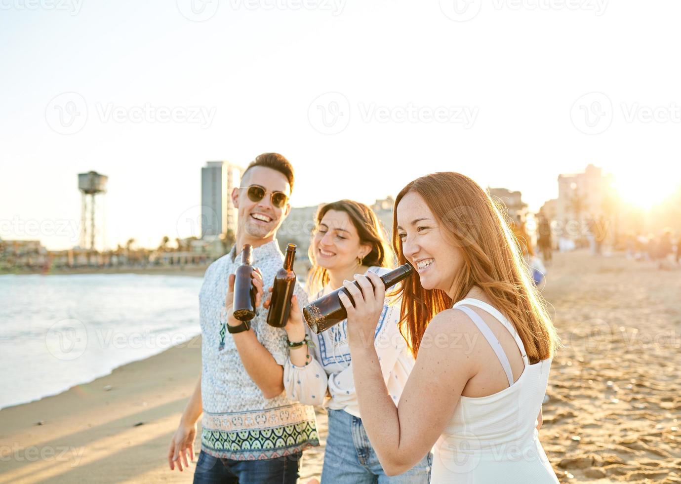 Friends drinking beer on the beach photo