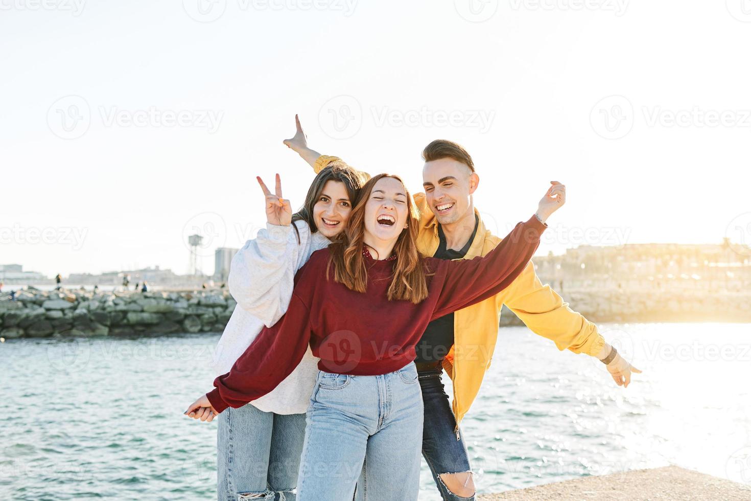 jóvenes amigos riendo juntos en la playa foto