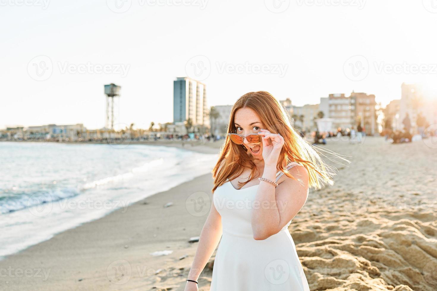 A happy red hair girl on the beach photo