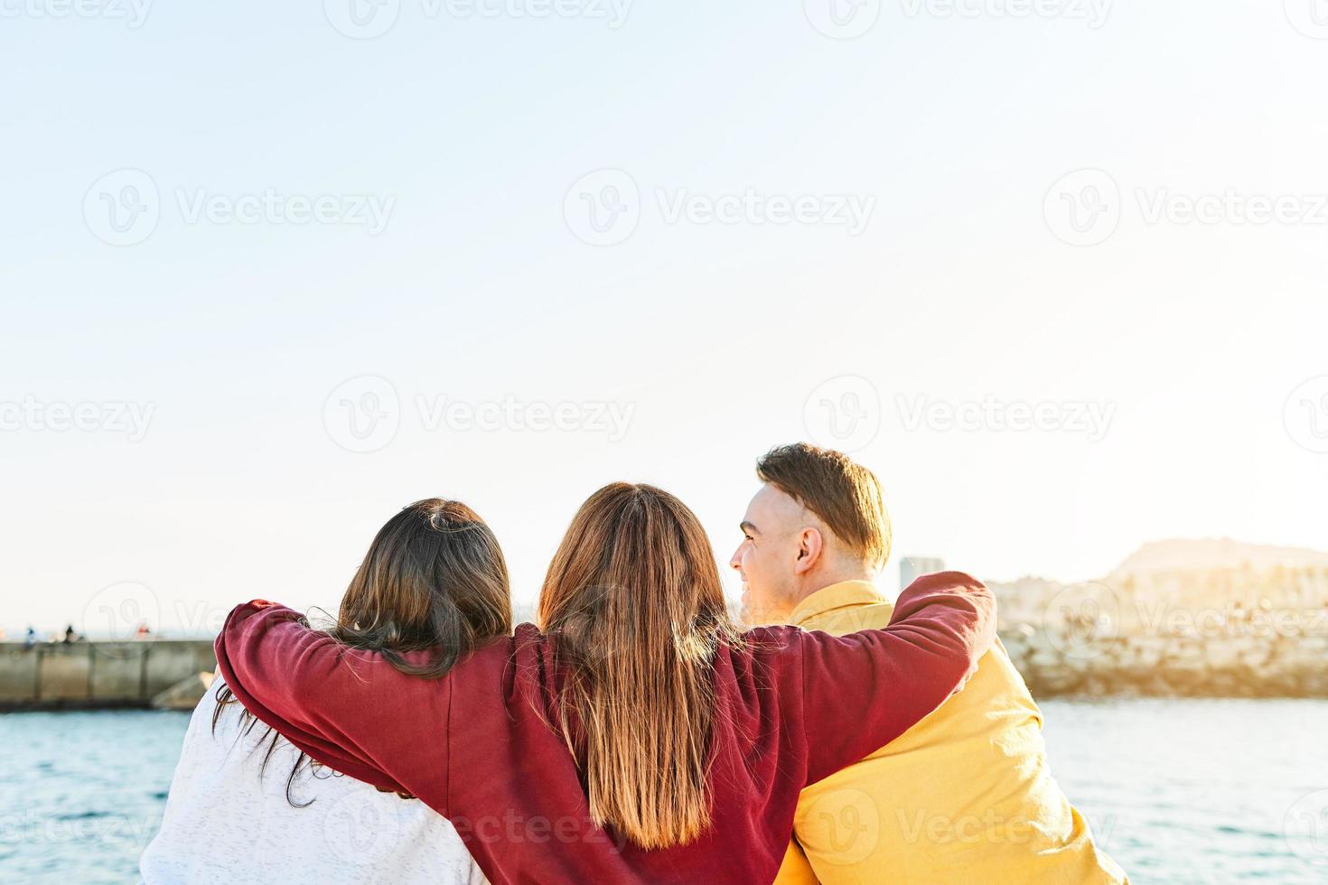 Friends with their backs to each other and hugging photo