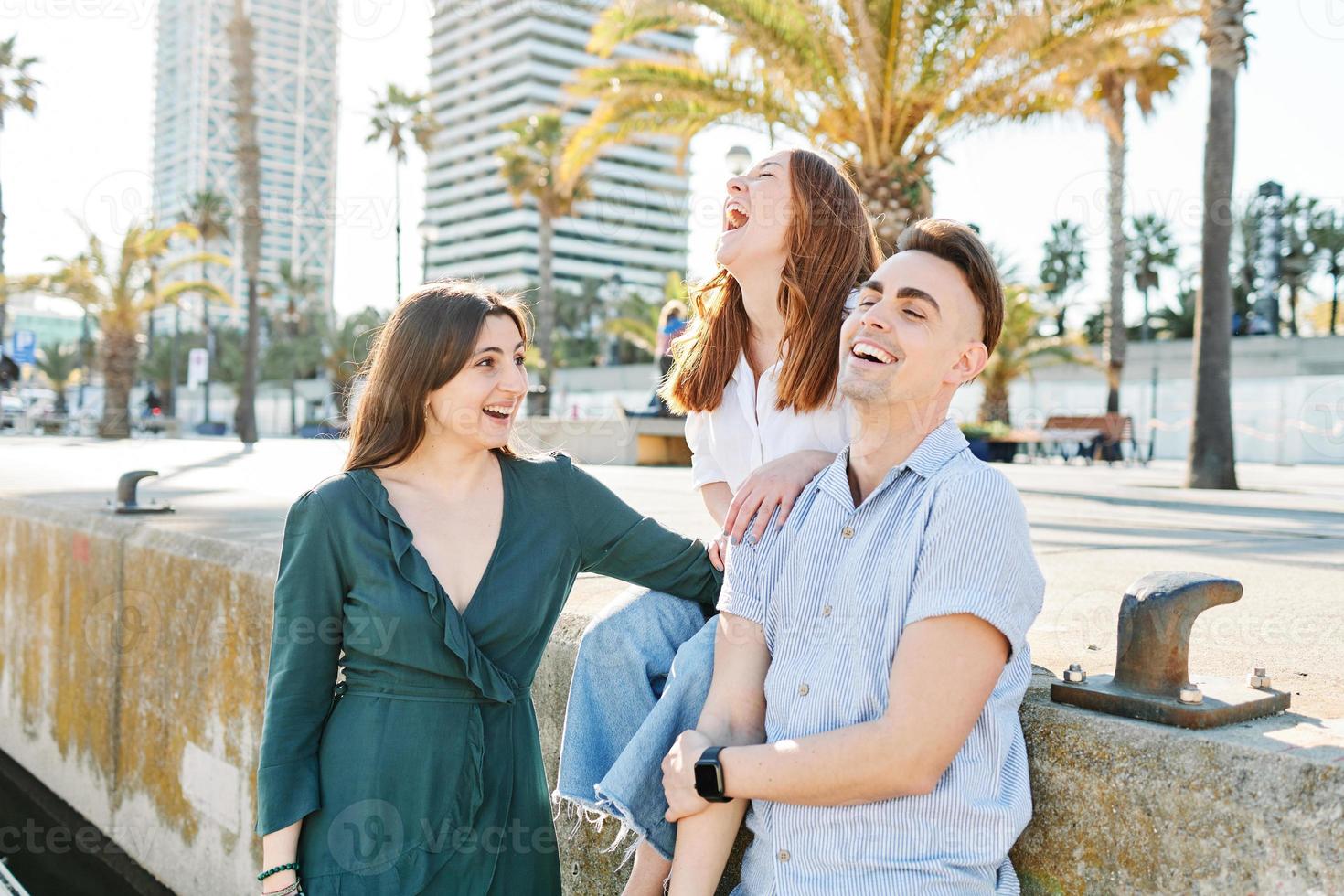 Friends laughing in the street in summer photo