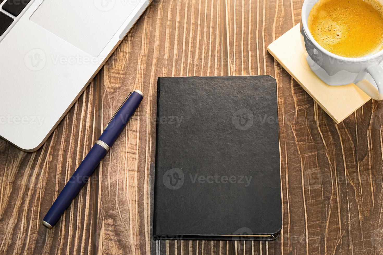 Laptop, diary and coffee cup on a wooden table. photo