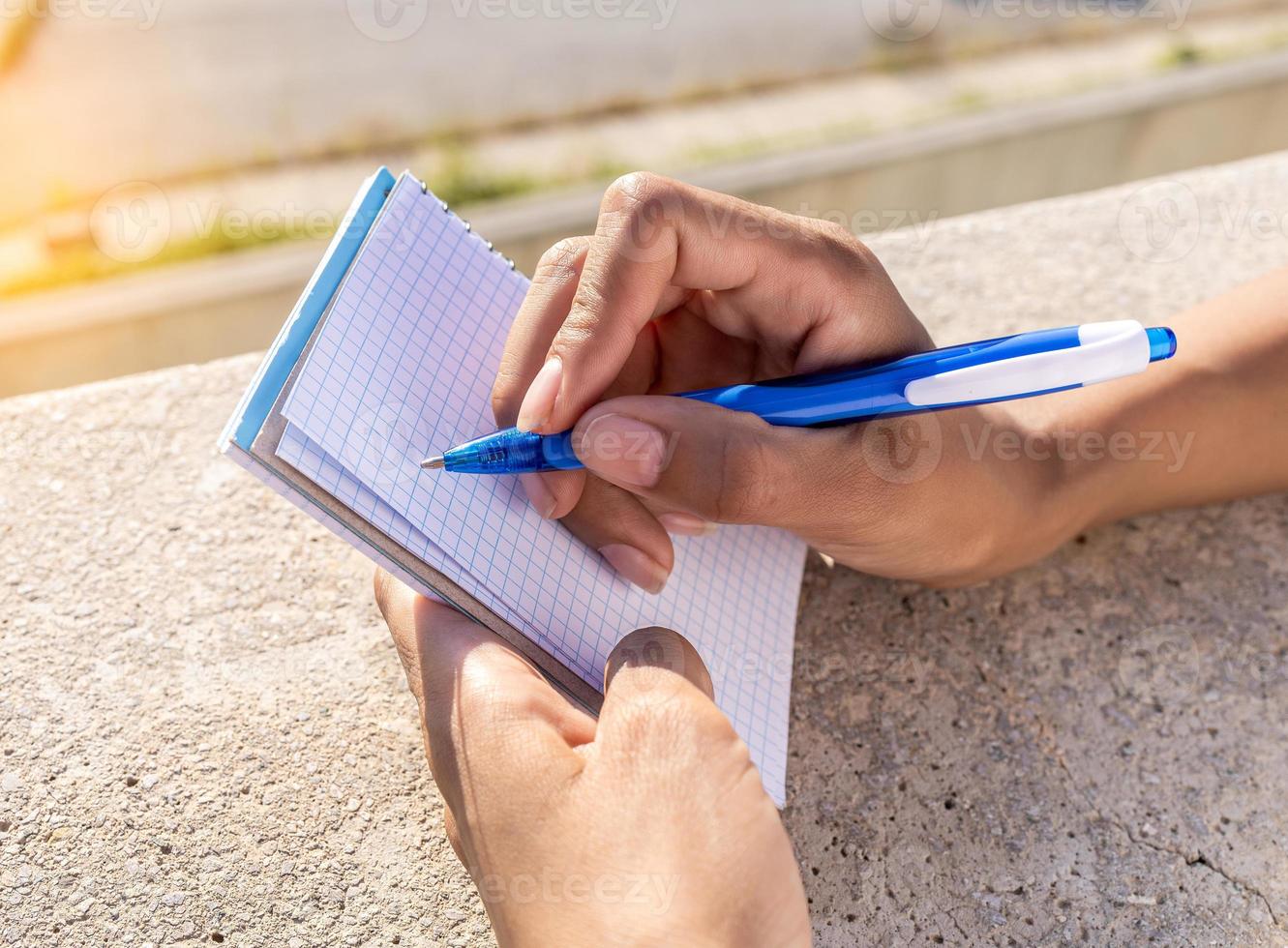 Person writing down her new ideas in a notebook photo