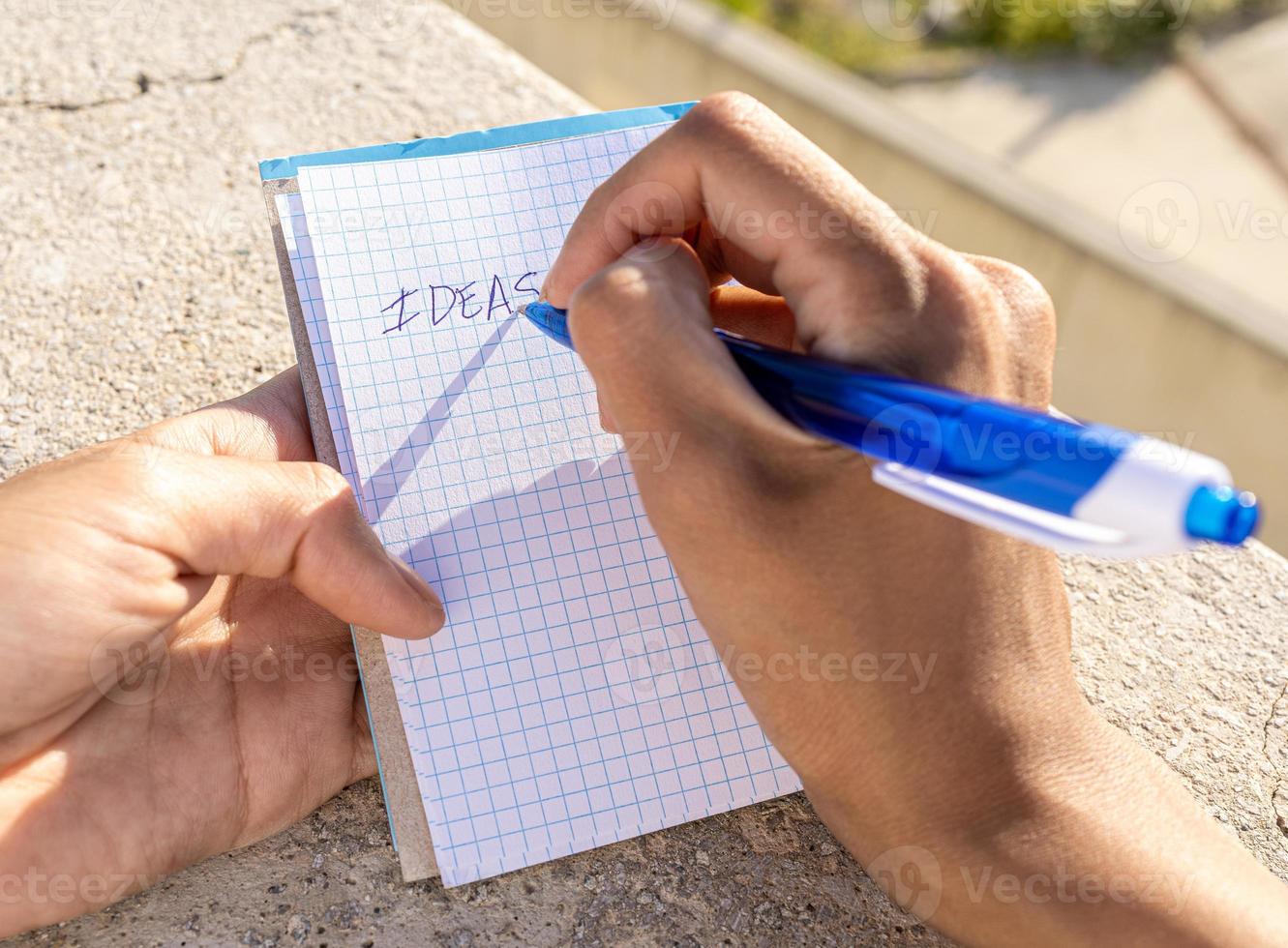 Person writing down her new ideas in a notebook photo