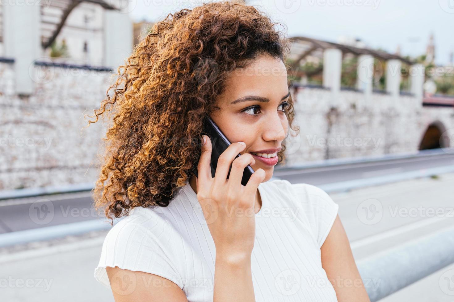 Latin girl talking on the smartphone. photo